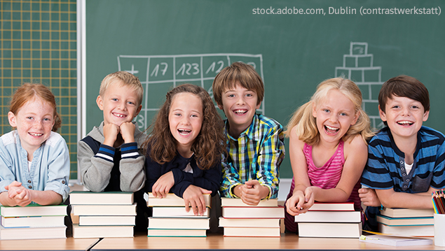 Grundschul-Blog_Grundschuljahr_WelttagBuch_Kinder_Buecher Kinder lehnen auf Bücherstapeln