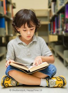 Junge_m_Buch Junge liest Buch in Bibliothek