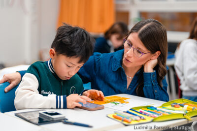 Grundschul-Blog-Grundschule-digital-Kind-Lehrkraft-Smartphone Grundschulkind mit Smartphone und Lehrerin