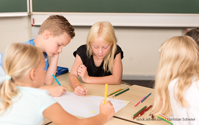 Grundschul-Blog-Unterrichten-Mathematik-Tag-der-Mathematik-Kinder-Schreibtisch Kinder sitzen an einem Schreibtisch in der Schule und zeichnen mit Buntstiften
